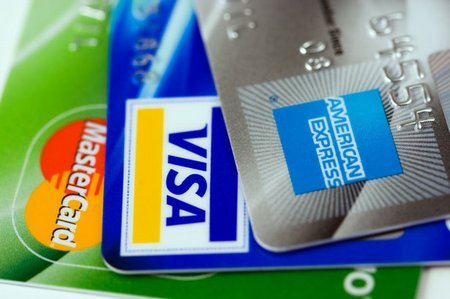 Three credit cards- Visa, Mastercard and American Express (close-up on logos)